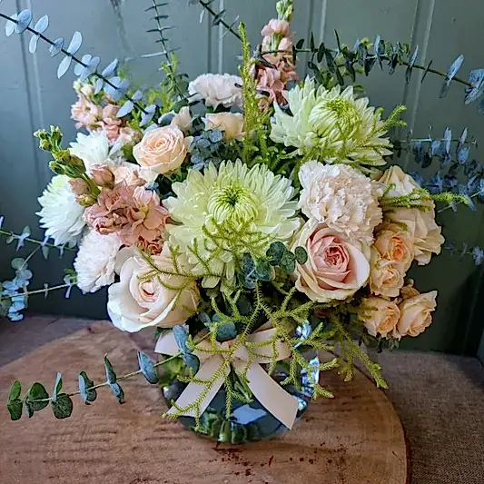 Peach and sage flowers in a fishbowl vase