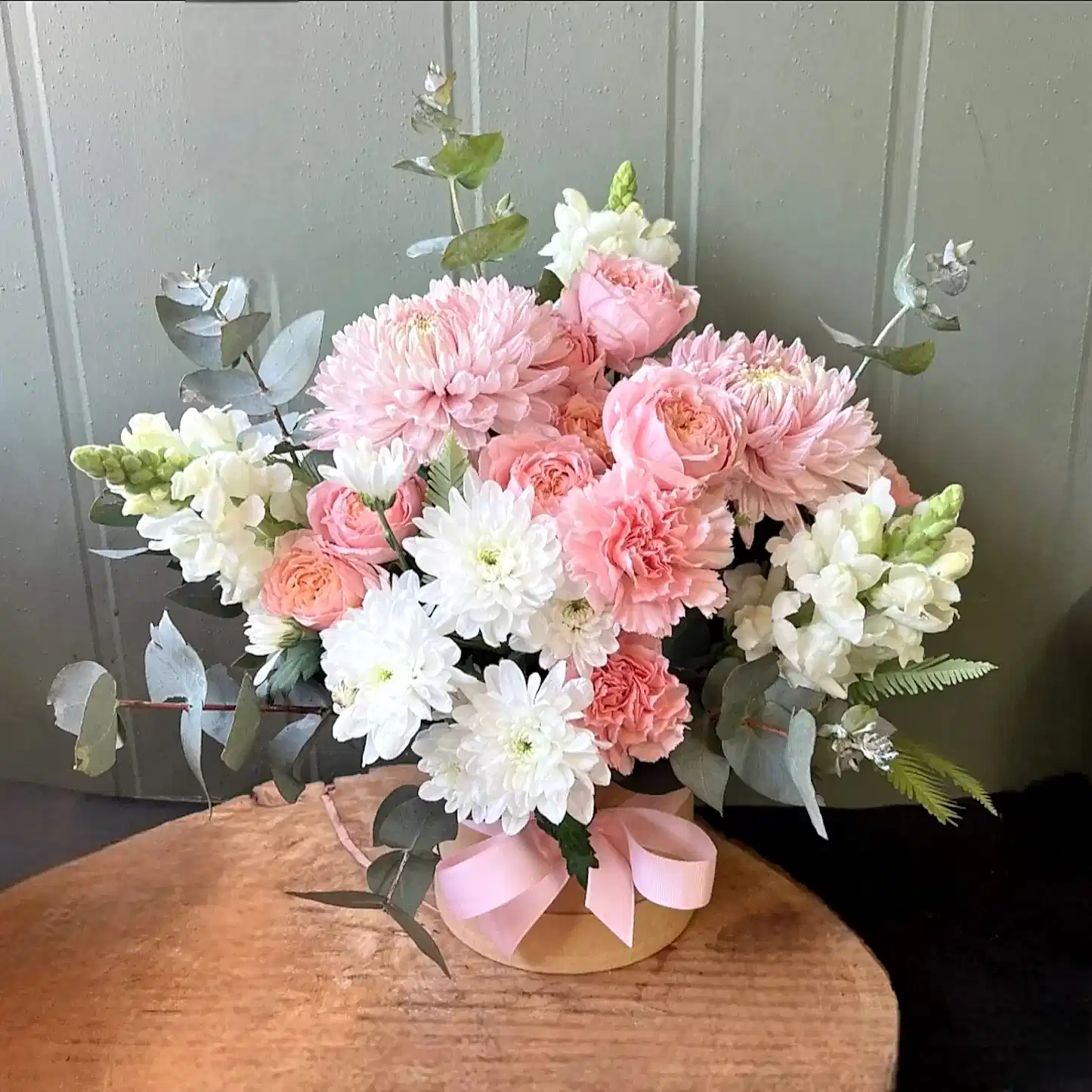 Pink and white tonal flowers arranged in a hatbox