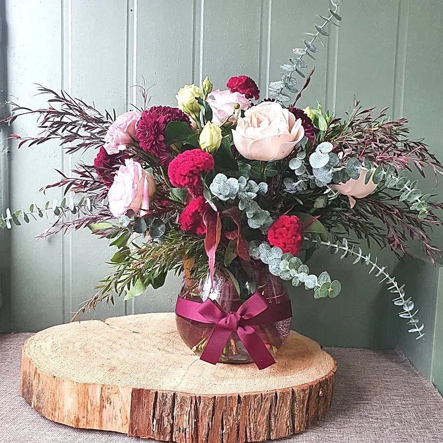 romantic flowers in fishbowl vase